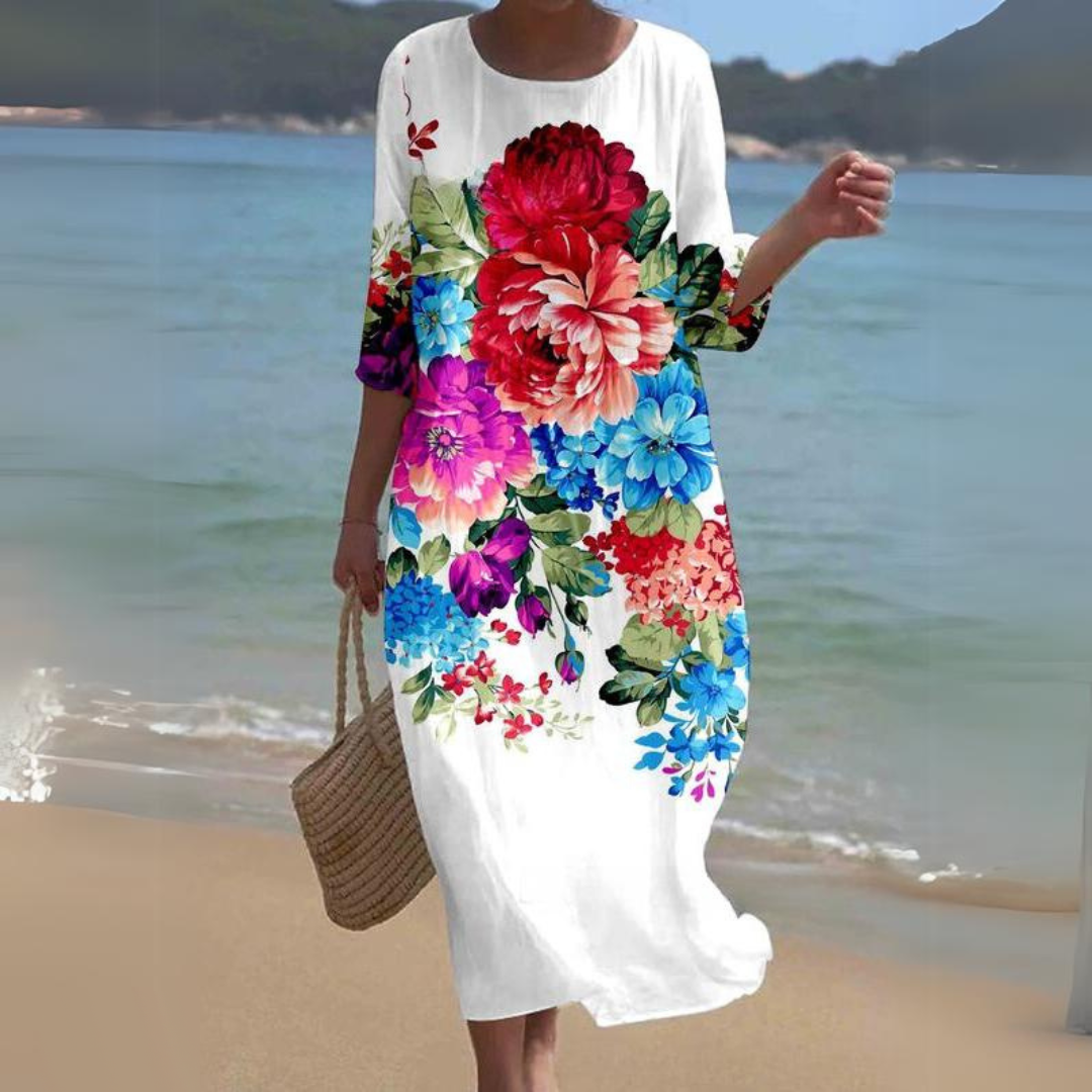 Elegant women's floral dress worn on the beach, paired with a woven handbag, perfect for summer outings and casual strolls.