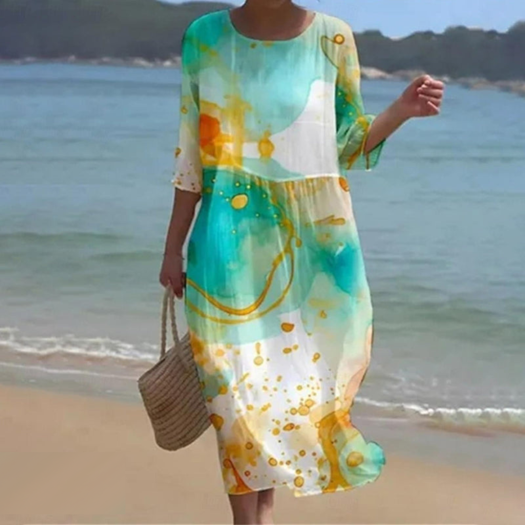 Elegant women's floral dress worn on the beach, paired with a woven handbag, perfect for summer outings and casual strolls.