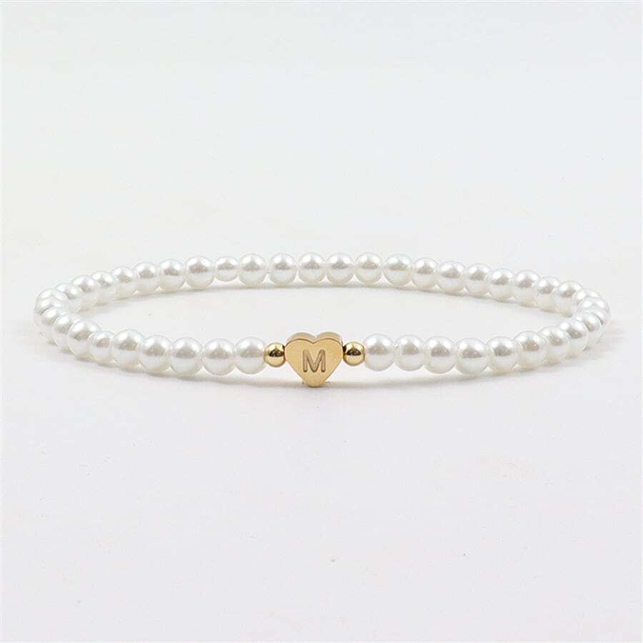 Close-up of the Luna Women's Pearl Bracelet featuring a delicate strand of pearls and a heart charm, worn on a wrist for an elegant and stylish look.