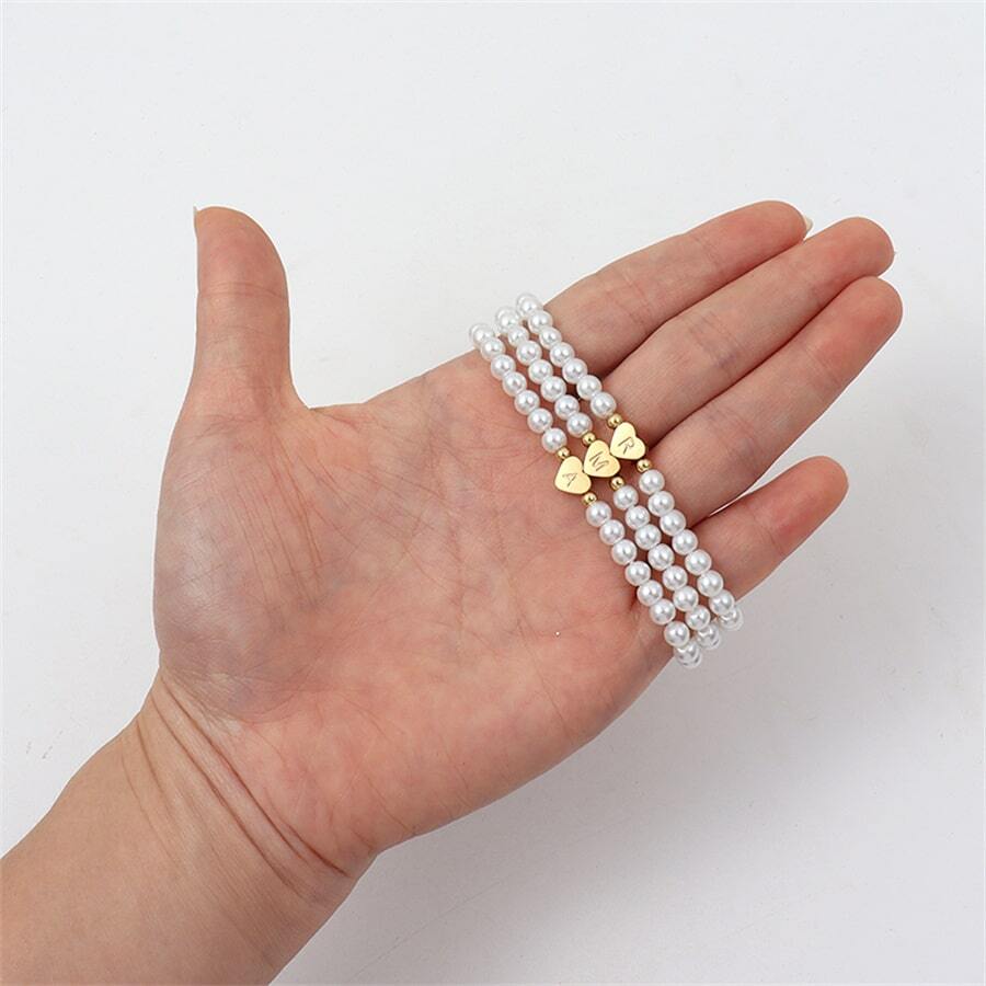 Close-up of the Luna Women's Pearl Bracelet featuring a delicate strand of pearls and a heart charm, worn on a wrist for an elegant and stylish look.