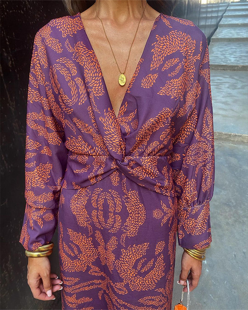 A close-up of a woman wearing the Nina Women's Elegant Wrap Dress, featuring a bold pattern and flattering wrap design with a deep V-neckline. The dress showcases intricate patterns and a knot detail at the waist, creating a sophisticated and stylish look suitable for special occasions.