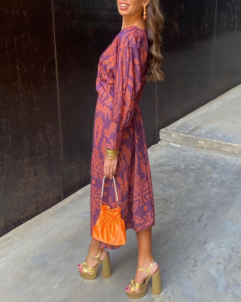 A close-up of a woman wearing the Nina Women's Elegant Wrap Dress, featuring a bold pattern and flattering wrap design with a deep V-neckline. The dress showcases intricate patterns and a knot detail at the waist, creating a sophisticated and stylish look suitable for special occasions.
