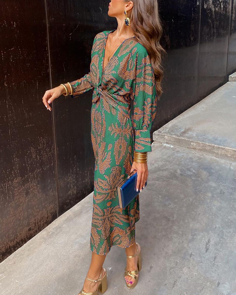 A close-up of a woman wearing the Nina Women's Elegant Wrap Dress, featuring a bold pattern and flattering wrap design with a deep V-neckline. The dress showcases intricate patterns and a knot detail at the waist, creating a sophisticated and stylish look suitable for special occasions.