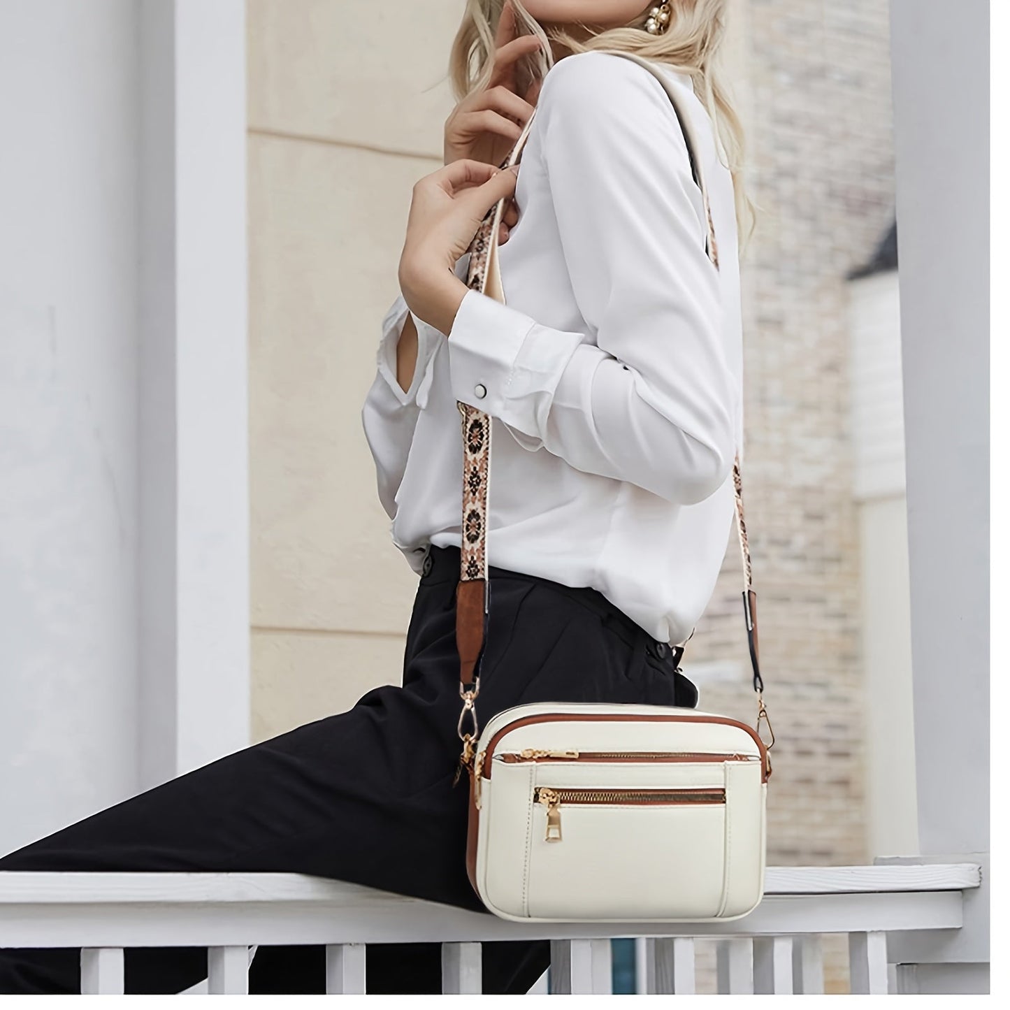 A woman sitting on a balcony railing wearing a stylish crossbody bag with an elegant design, featuring multiple compartments and an adjustable strap, ideal for everyday use.
