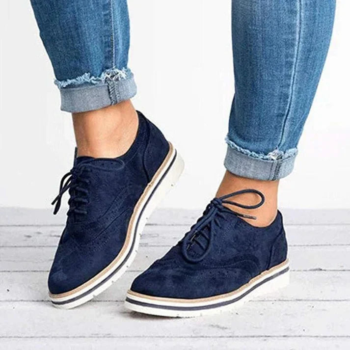 Image showing women's classic sneakers with a stylish brogue design, featuring lace-up closure and a comfortable sole, perfect for casual wear.
