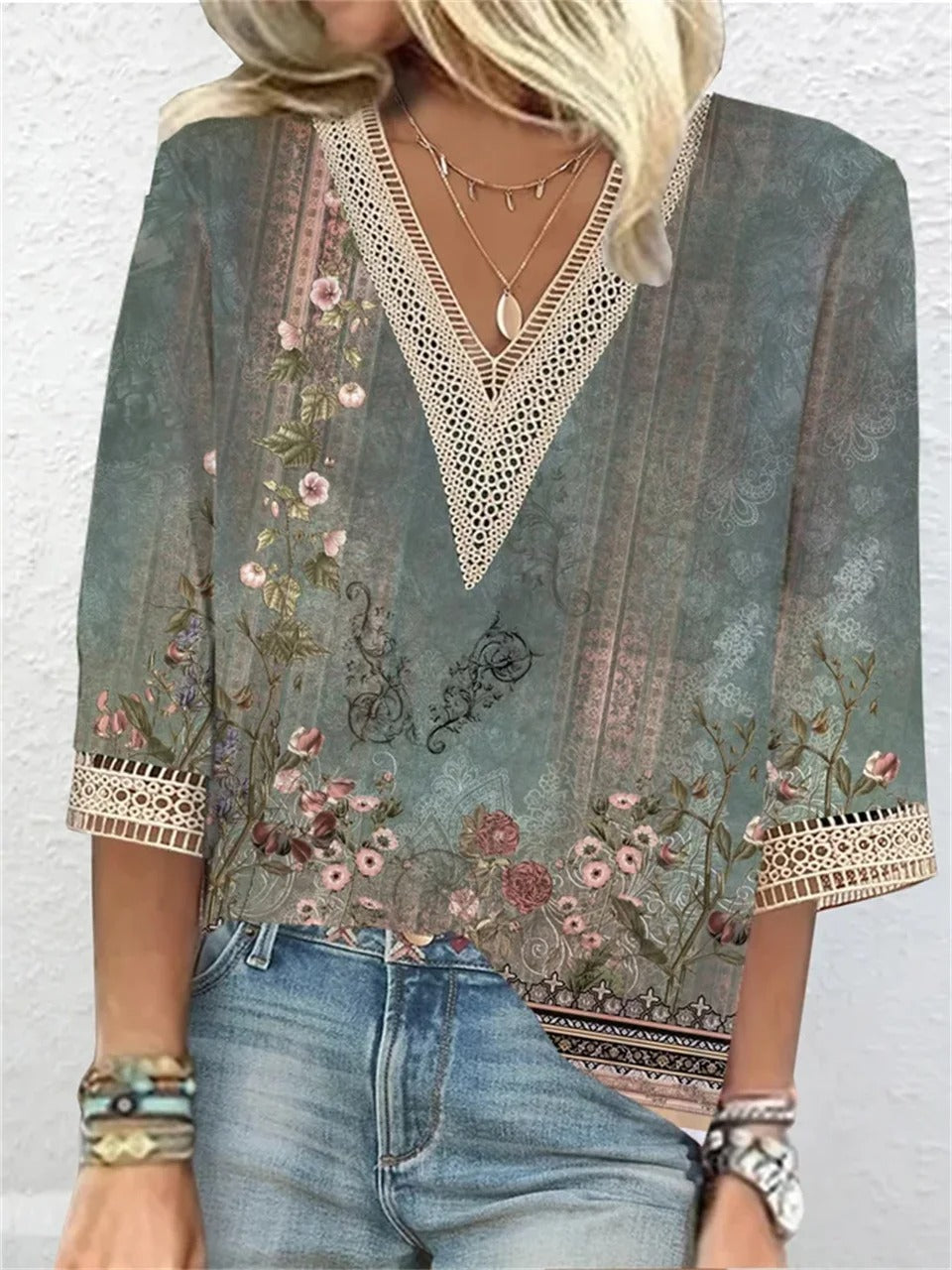 Elegant women's blouse with intricate design details, paired with jeans and accessories, perfect for casual or semi-formal occasions.