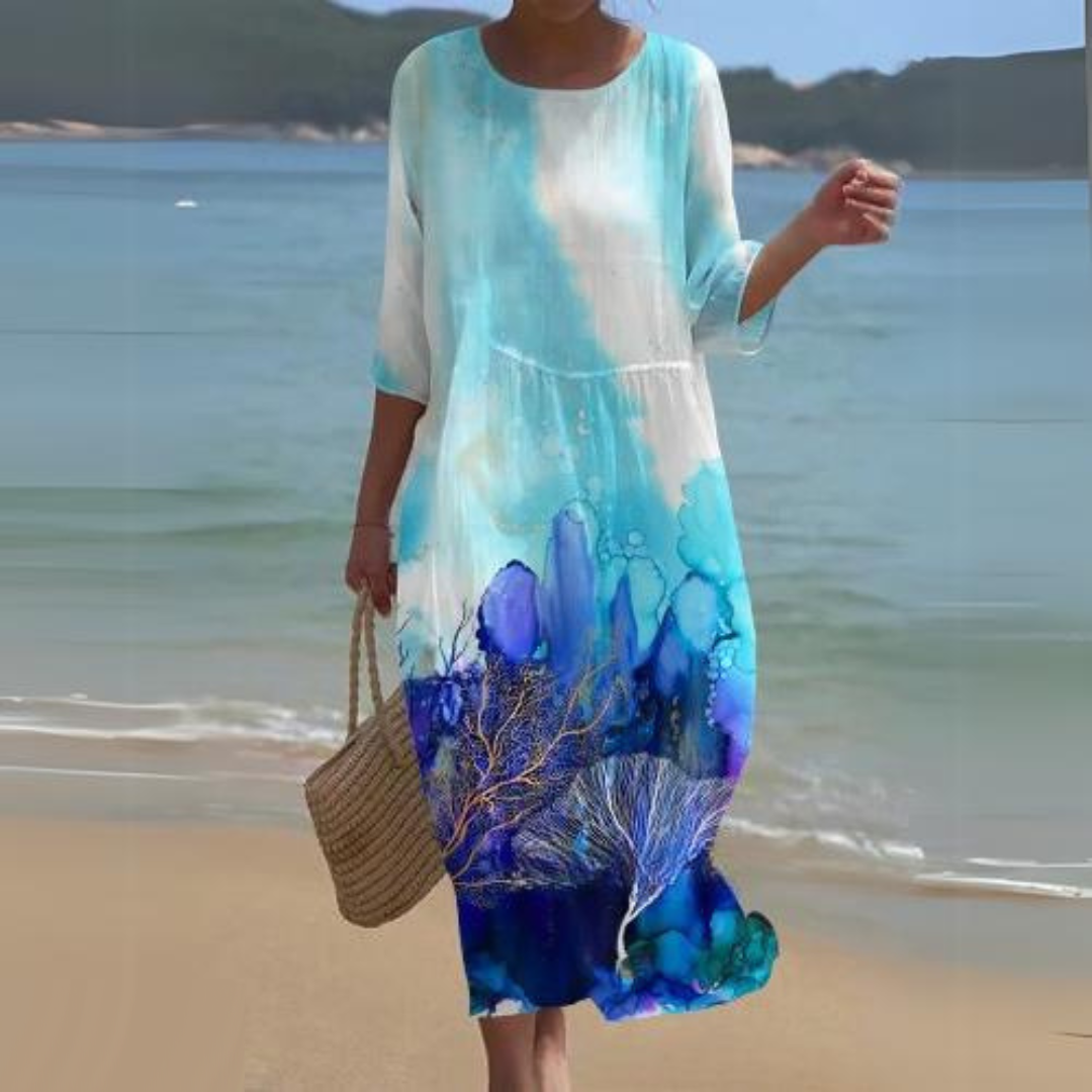 Elegant women's floral dress worn on the beach, paired with a woven handbag, perfect for summer outings and casual strolls.