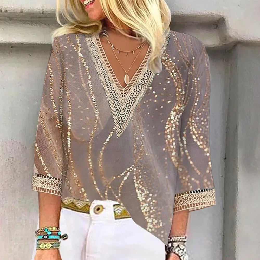 Elegant women's blouse with intricate design details, paired with jeans and accessories, perfect for casual or semi-formal occasions.