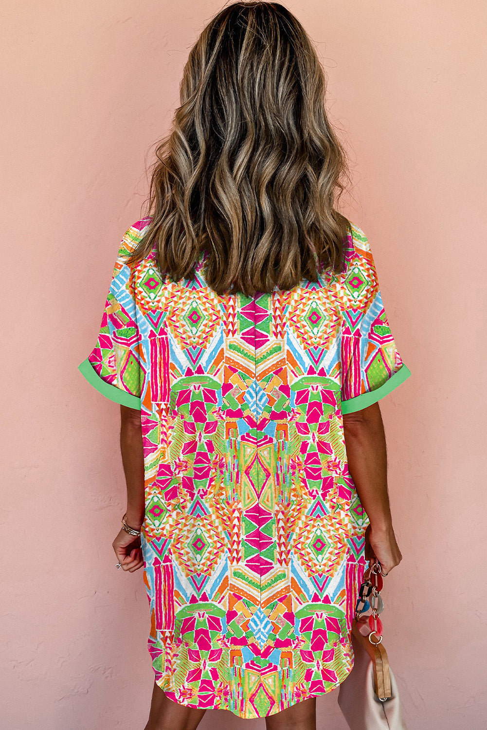 Woman wearing the Zara Women's Geometric Button-Down Dress with a vibrant pattern, accessorized with a handbag and bold jewelry. The dress features a relaxed fit and geometric design, perfect for a stylish and casual look.