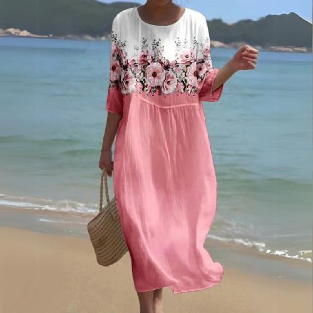 Elegant women's floral dress worn on the beach, paired with a woven handbag, perfect for summer outings and casual strolls.