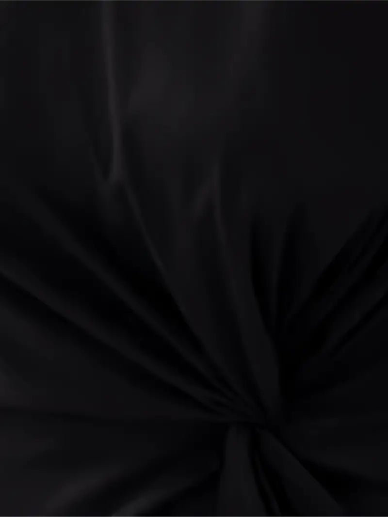 A woman wearing an elegant dress with a flattering ruched design, perfect for both casual outings and formal events. The dress highlights a sophisticated and stylish silhouette, paired with a clutch for a polished look.