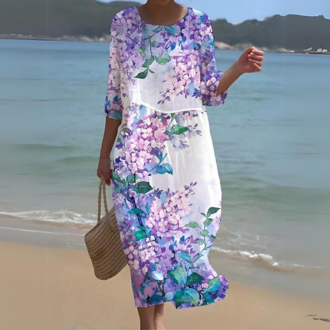 Elegant women's floral dress worn on the beach, paired with a woven handbag, perfect for summer outings and casual strolls.