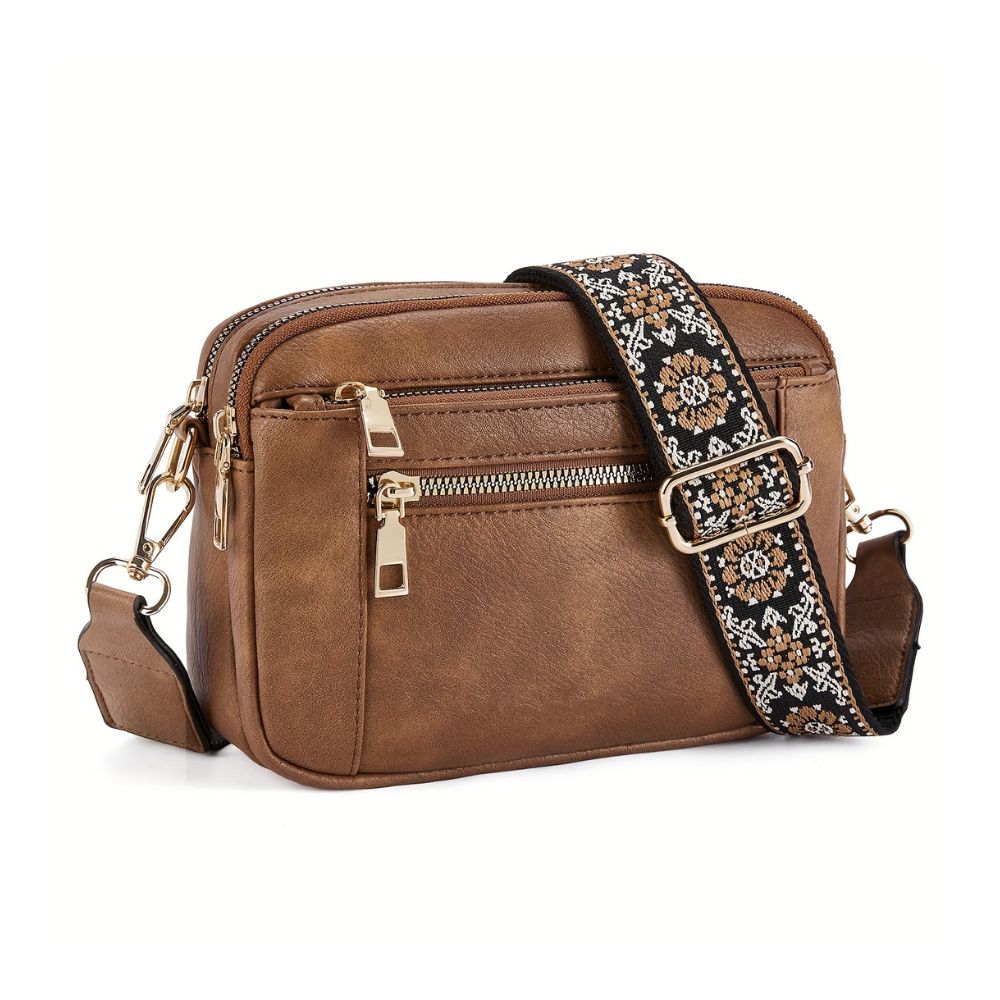 A woman sitting on a balcony railing wearing a stylish crossbody bag with an elegant design, featuring multiple compartments and an adjustable strap, ideal for everyday use.