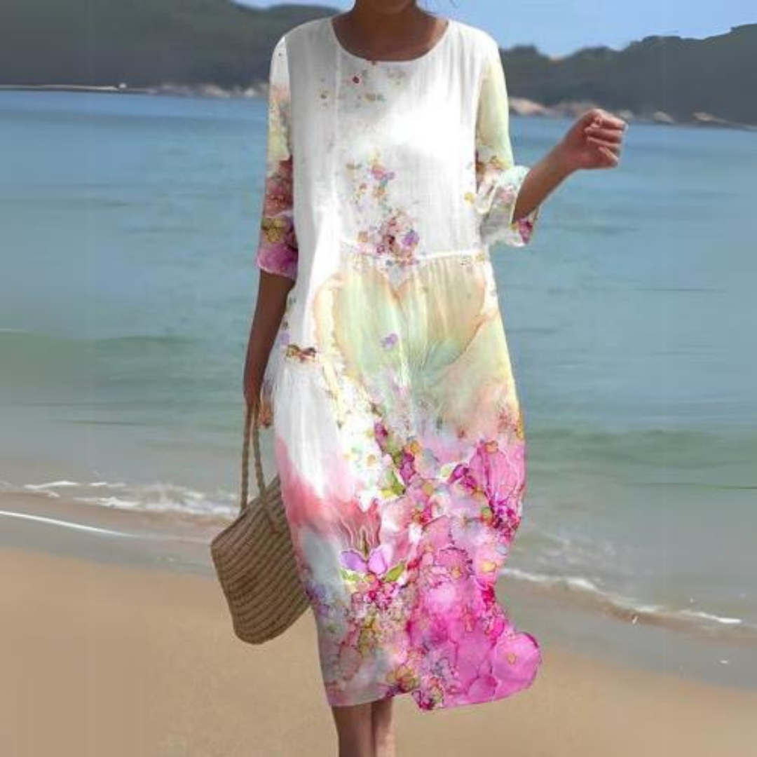 Elegant women's floral dress worn on the beach, paired with a woven handbag, perfect for summer outings and casual strolls.