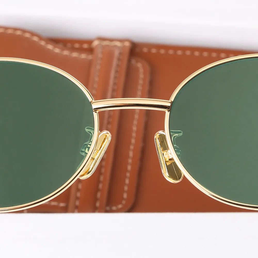 A pair of elegant women's sunglasses with a chic oval frame and stylish detailing, perfect for enhancing any outfit and providing essential UV protection. Designed for a lightweight and comfortable fit, ideal for daily wear or special occasions.