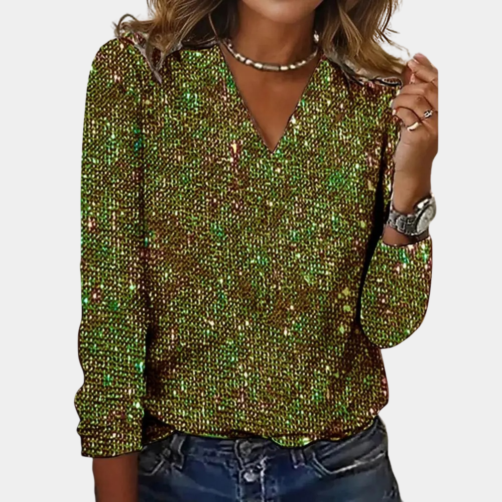 A woman wearing a sparkling V-neck top paired with denim jeans and accessorized with layered necklaces and a watch. The top features a glamorous design, perfect for parties, special occasions, or casual chic outfits.