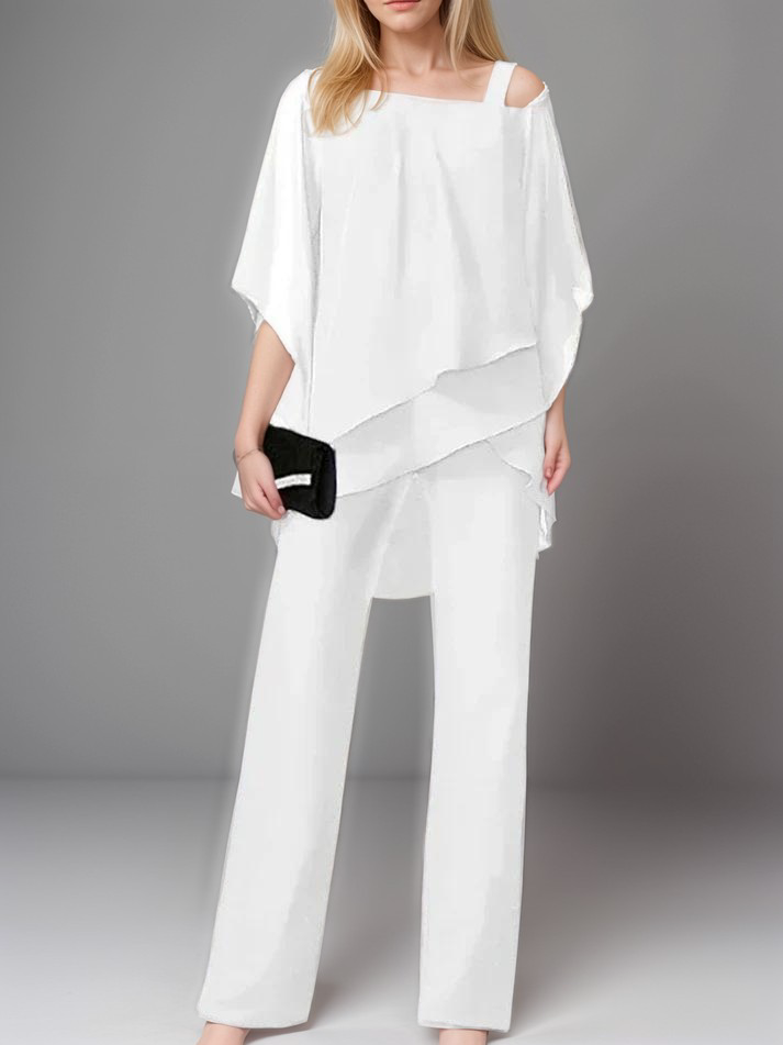 A stylish woman wearing the Sophia | Women's Layered Jumpsuit | Elegant Jumpsuit, featuring a flowing layered top and tailored wide-leg pants, accessorized with a clutch bag and heels, perfect for formal or special occasions.