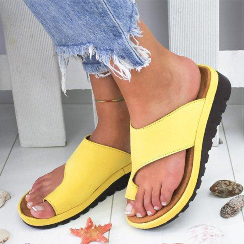 Stylish women's sandals with a comfortable fit, designed for casual wear and summer outings, paired with white pants for a chic look.