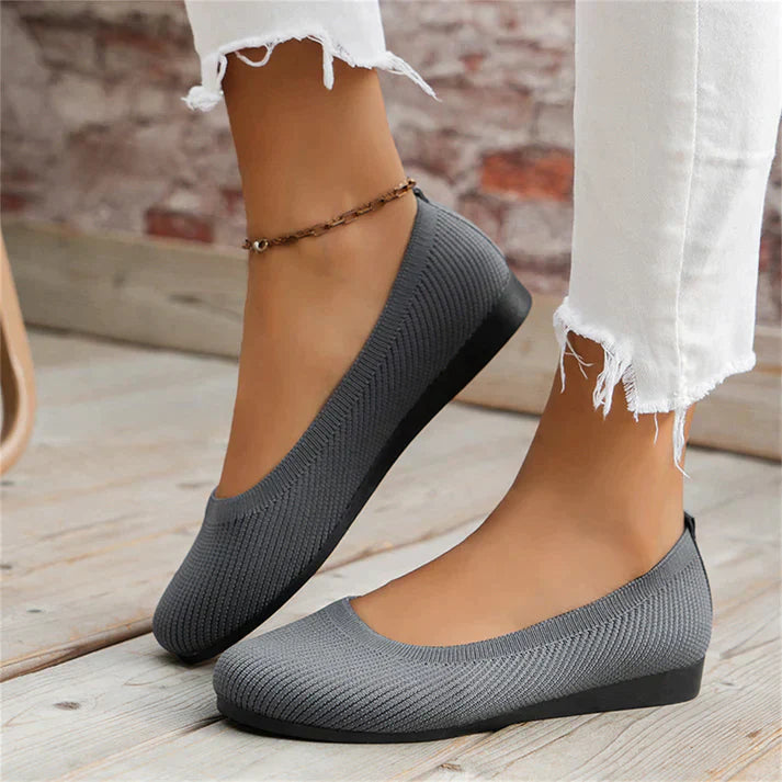 A pair of Lily Women's Stylish Comfort Shoes, designed as slip-on shoes with a textured fabric finish and cushioned insole, held by a person showcasing the lightweight and comfortable design ideal for everyday wear.