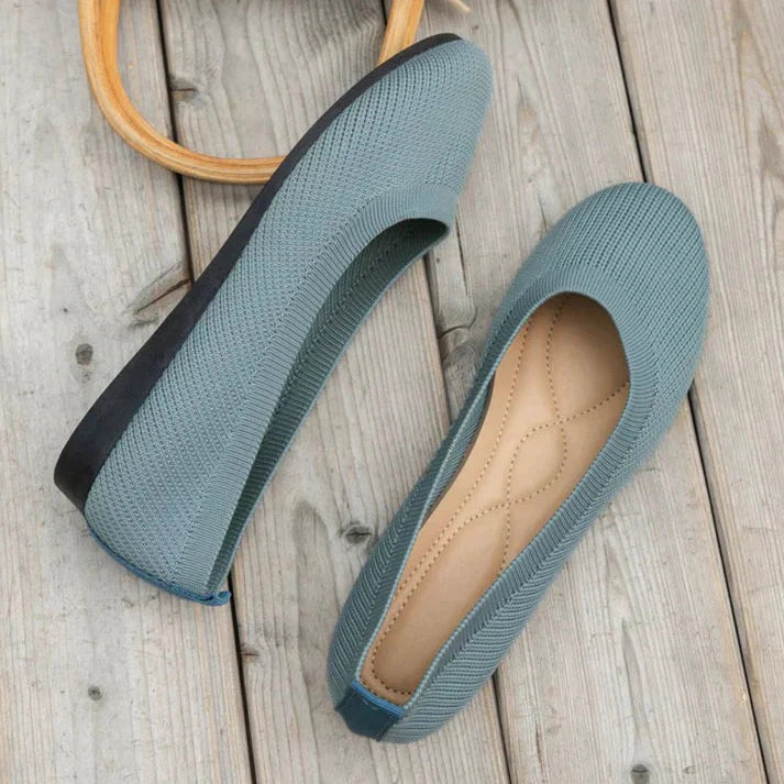 A pair of Lily Women's Stylish Comfort Shoes, designed as slip-on shoes with a textured fabric finish and cushioned insole, held by a person showcasing the lightweight and comfortable design ideal for everyday wear.