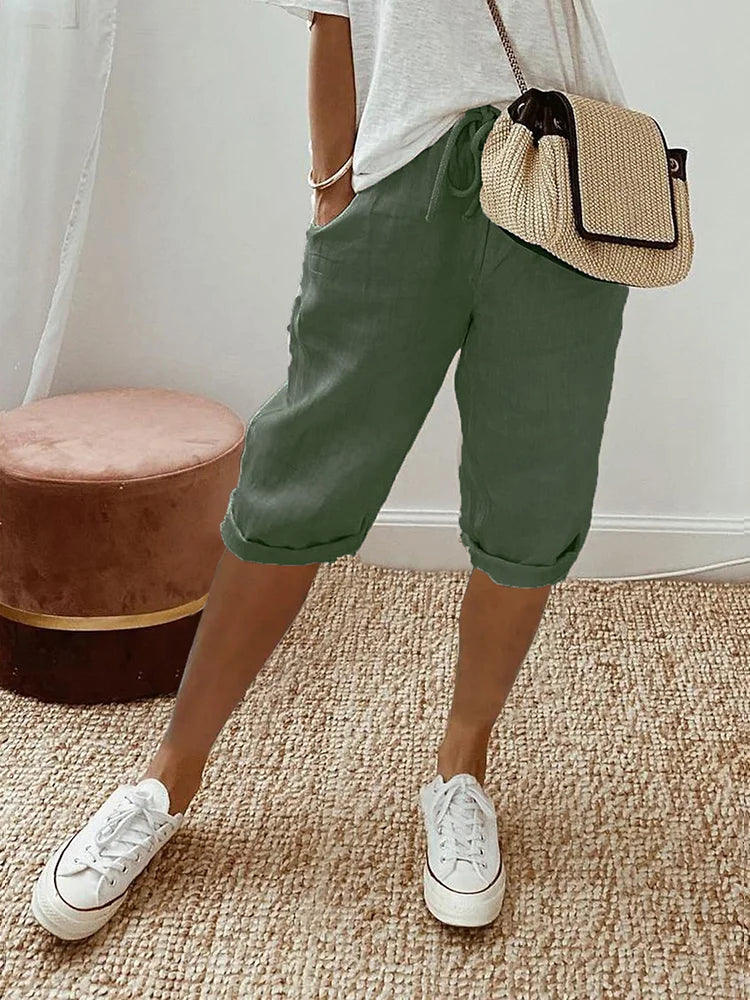 Women's relaxed-fit shorts paired with casual sneakers and a stylish woven bag, perfect for a comfortable and chic everyday look.