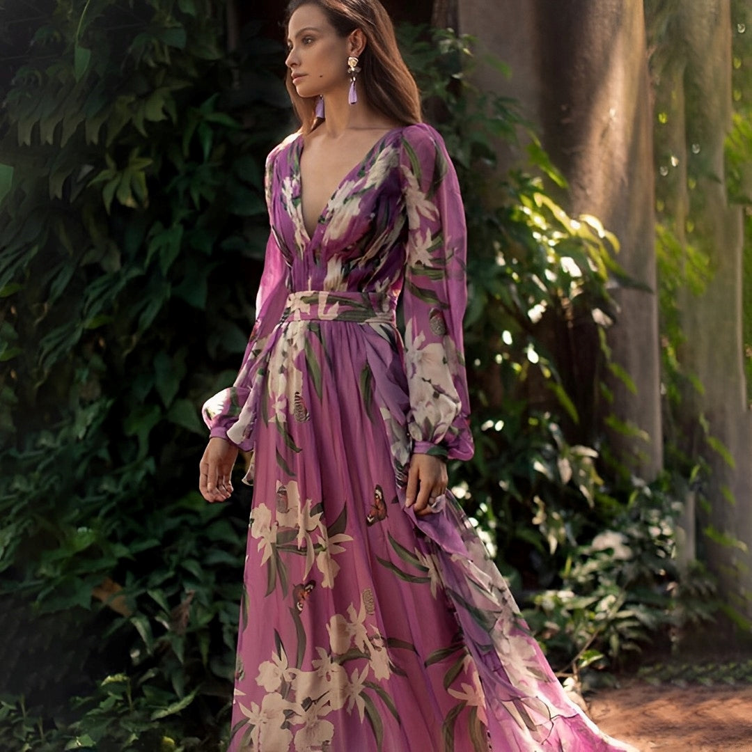 Woman wearing the Elara Women's Floral Chiffon Dress, an elegant long dress with a delicate floral design, flowy long sleeves, and a fitted waist, posing gracefully outdoors amidst lush greenery.