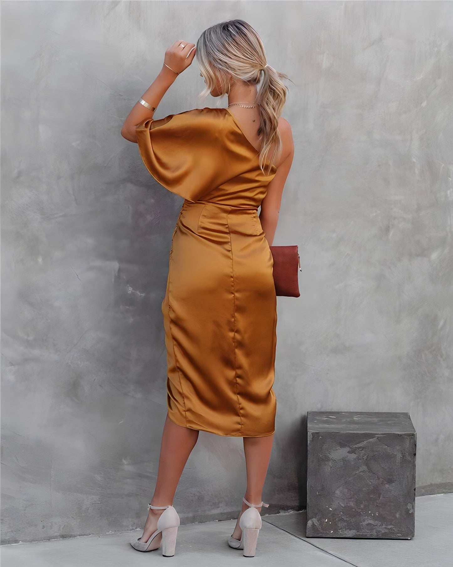 A woman standing in front of a decorated Christmas tree, wearing a stylish one-shoulder party dress with a ruched wrap design. The dress features an elegant silhouette, perfect for festive celebrations and special events. She is smiling and ready for the occasion.