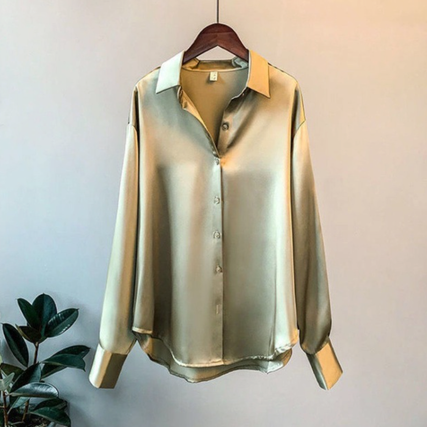 Elegant women's satin button-up shirt featuring a timeless design, styled for both casual and formal occasions, paired with a sophisticated clutch for a chic look.