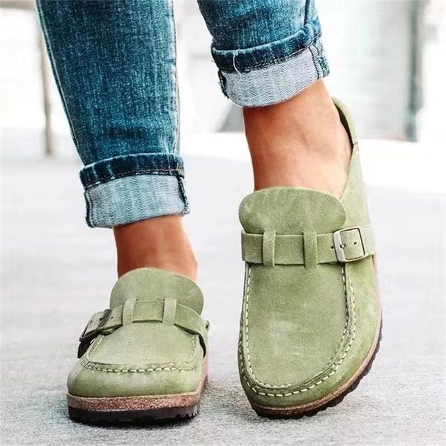 Women's stylish loafers with a comfortable design, featuring a slip-on style and elegant buckle detail, paired with rolled-up denim jeans for a casual look.