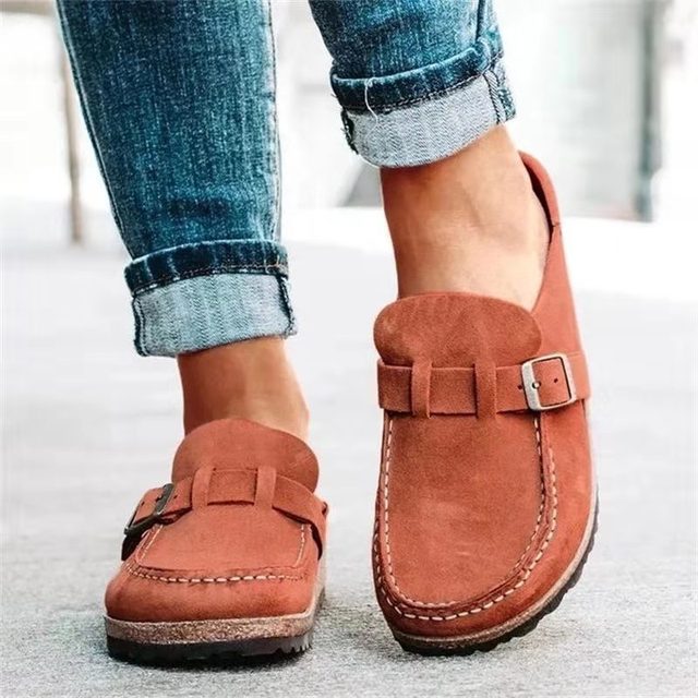 Women's stylish loafers with a comfortable design, featuring a slip-on style and elegant buckle detail, paired with rolled-up denim jeans for a casual look.