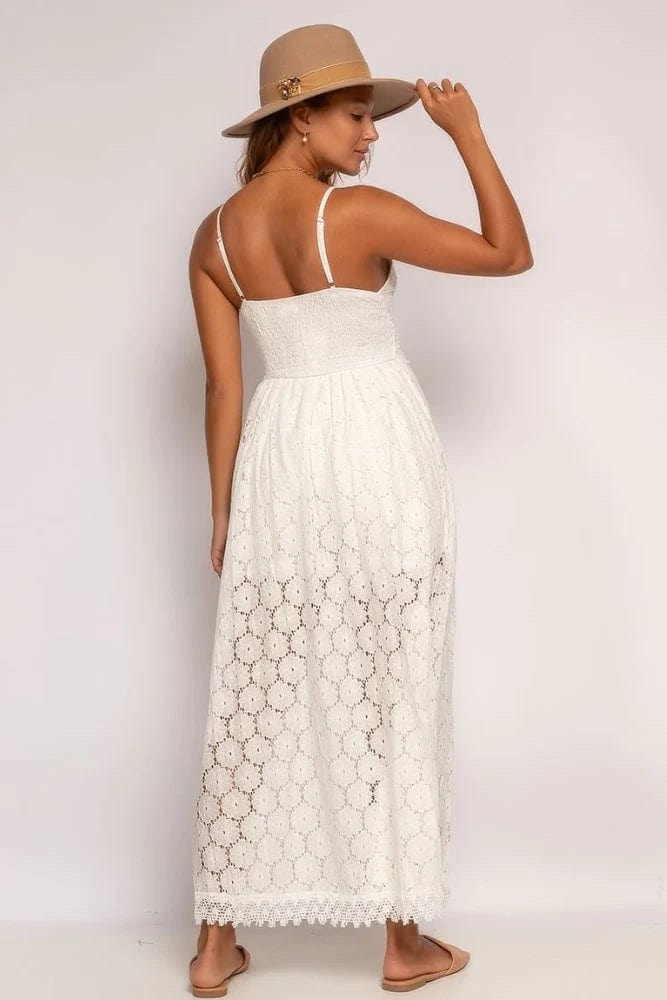 A woman wearing the Lily Women's Lace Overlay Dress, a boho-inspired romper dress with a flowing lace overlay and adjustable straps, styled with a wide-brimmed hat and flat sandals. Perfect for casual outings, beach days, and summer festivals, combining elegance with a relaxed bohemian look.