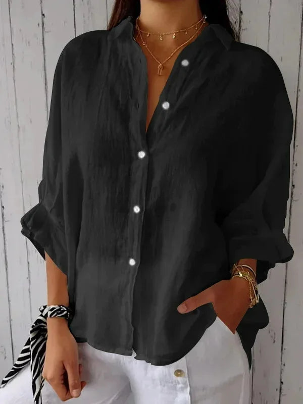 A relaxed-fit women's blouse with a button-up front, long sleeves, and a lightweight, flowy design, styled casually for versatile wear.