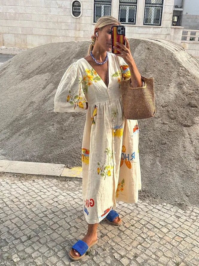 A fashionable woman taking a mirror selfie outdoors, wearing the Sophia | Women's Printed Midi Dress | Puff Sleeve Dress, styled with a woven bag, matching accessories, and flat sandals, showcasing the dress's elegant design and comfortable fit.