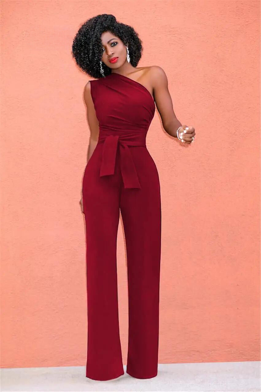A woman wearing a stylish one-shoulder jumpsuit with a tie waist and wide-leg design, creating an elegant and modern look. The outfit is perfect for formal occasions or evening events, combining sophistication with a bold fashion statement.