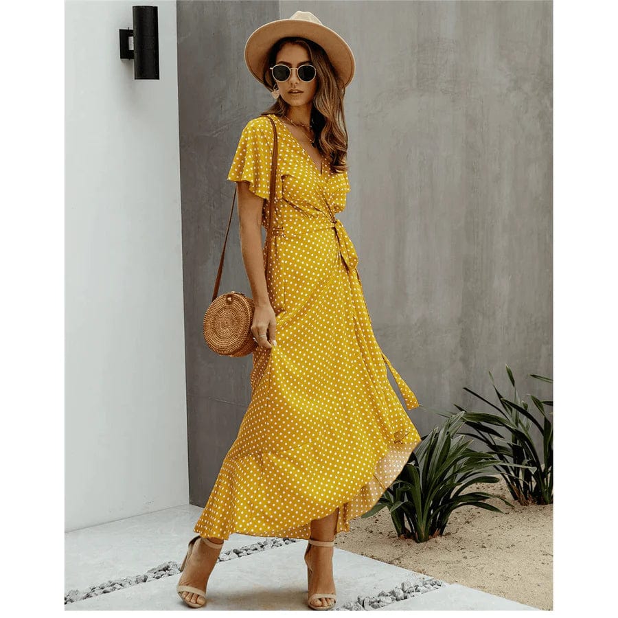 Image of a woman wearing the Mila Women's Flowy Wrap Dress, a stylish midi dress with a wrap design, flutter sleeves, and a flowing skirt, perfect for casual and semi-formal occasions. The dress exudes effortless elegance and complements any outdoor or relaxed setting.