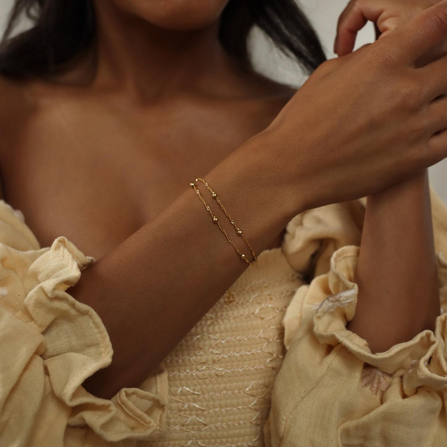 Close-up of a model wearing the Sofia Women's Delicate Bracelet, featuring a minimalist and elegant design, perfect for adding a subtle touch of sophistication to any outfit.