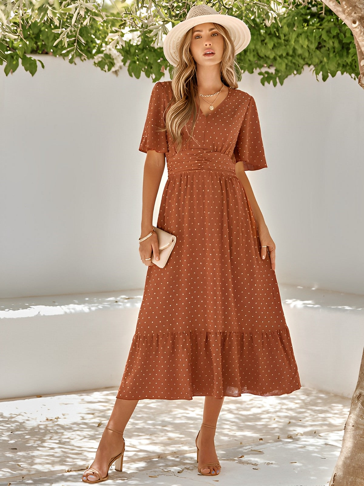 Woman wearing the Sophie | Elegant V-Neck Midi Dress with a flowing skirt and cinched waist, styled with a wide-brimmed hat and heels, perfect for an effortlessly chic and sophisticated look at any event.