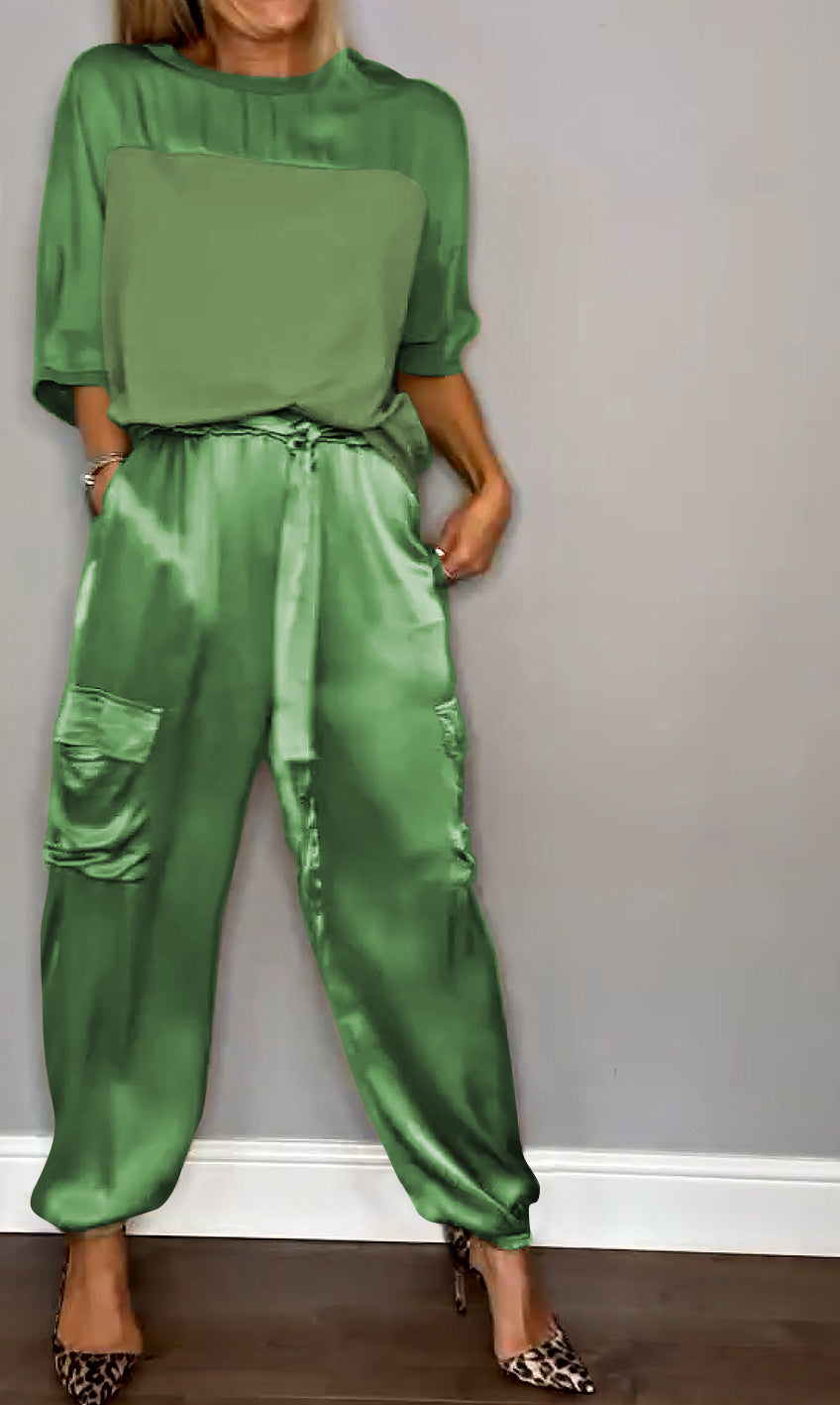 Image showcasing a stylish satin jumpsuit with a relaxed fit, featuring a belt at the waist and practical side pockets, perfect for an elegant yet comfortable look.