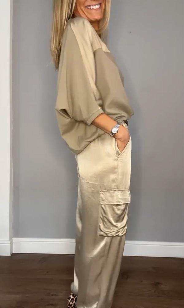 Image showcasing a stylish satin jumpsuit with a relaxed fit, featuring a belt at the waist and practical side pockets, perfect for an elegant yet comfortable look.