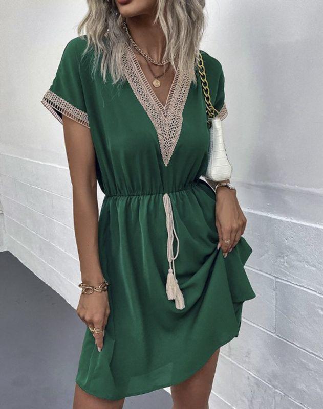 Woman wearing the Leah | Boho V-Neck Drawstring Dress with a relaxed fit and delicate detailing around the neckline. The dress is styled with a cinched waist, achieved through a drawstring, and paired with layered necklaces and a stylish handbag for a chic bohemian look.