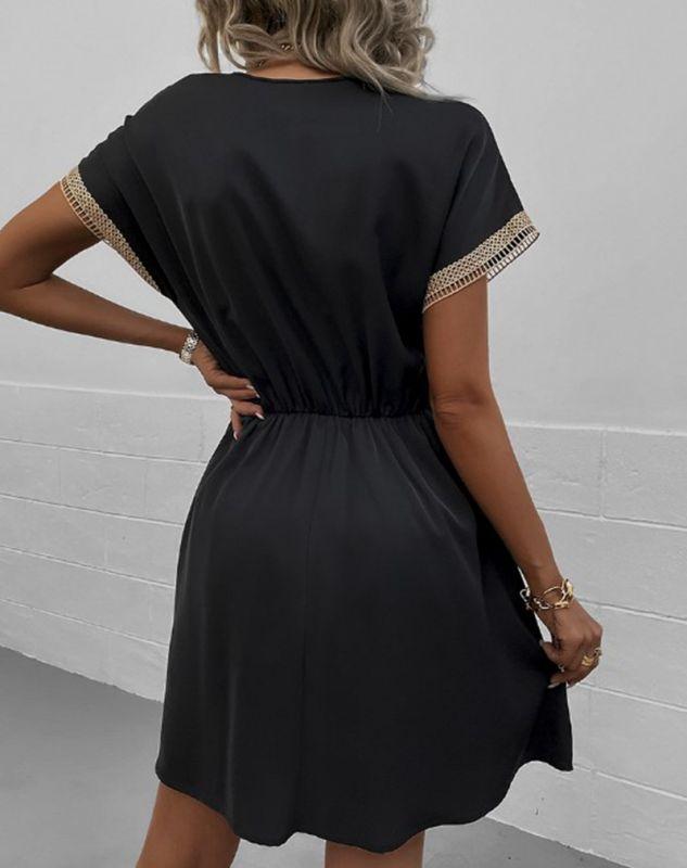 Woman wearing the Leah | Boho V-Neck Drawstring Dress with a relaxed fit and delicate detailing around the neckline. The dress is styled with a cinched waist, achieved through a drawstring, and paired with layered necklaces and a stylish handbag for a chic bohemian look.