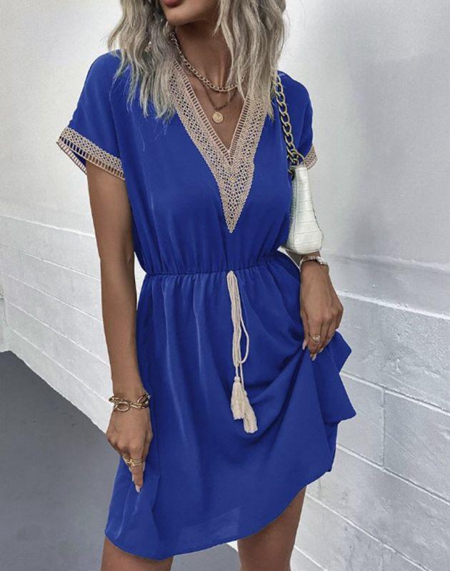 Woman wearing the Leah | Boho V-Neck Drawstring Dress with a relaxed fit and delicate detailing around the neckline. The dress is styled with a cinched waist, achieved through a drawstring, and paired with layered necklaces and a stylish handbag for a chic bohemian look.