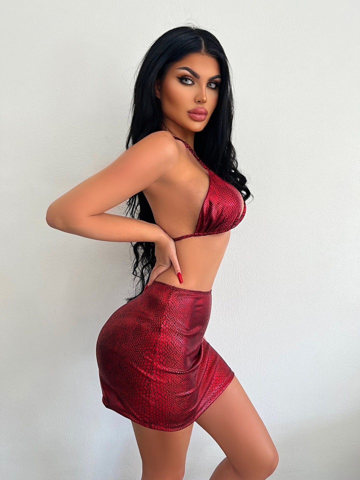 Model wearing the Mia | Bold Two-Piece Mini Skirt Set, featuring a daring bikini-style top and a form-fitting mini skirt. Perfect for a night out or special events, this set showcases a bold, confident look.