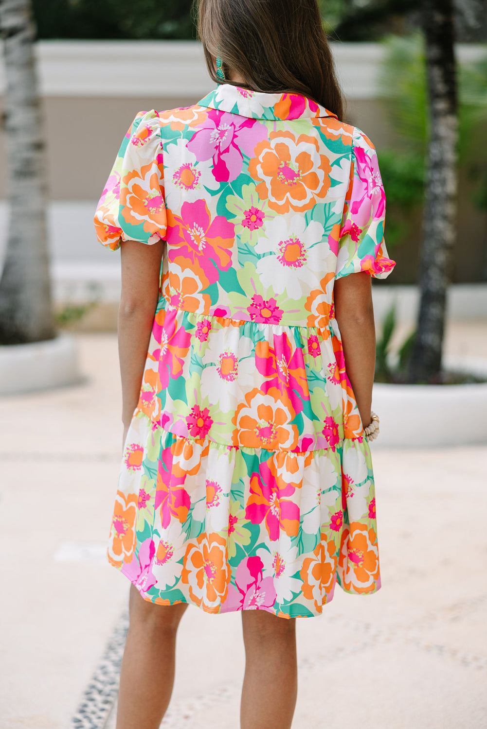 Back view of the Lily Women's Floral Tiered Dress, showcasing a vibrant floral pattern with tiered layers and short puff sleeves.