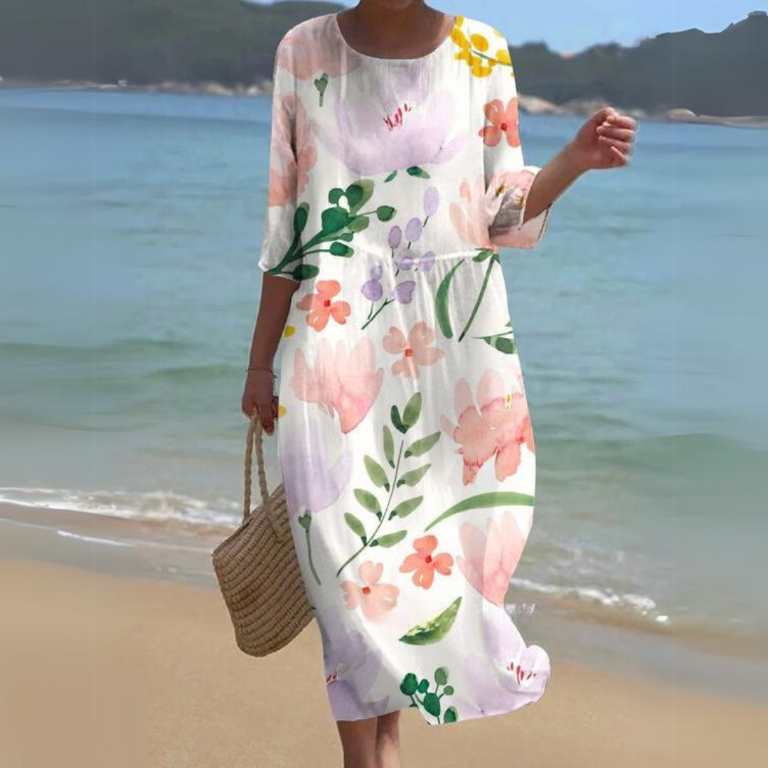 Elegant women's floral dress worn on the beach, paired with a woven handbag, perfect for summer outings and casual strolls.