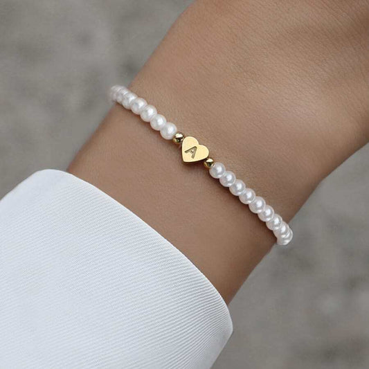 Close-up of the Luna Women's Pearl Bracelet featuring a delicate strand of pearls and a heart charm, worn on a wrist for an elegant and stylish look.