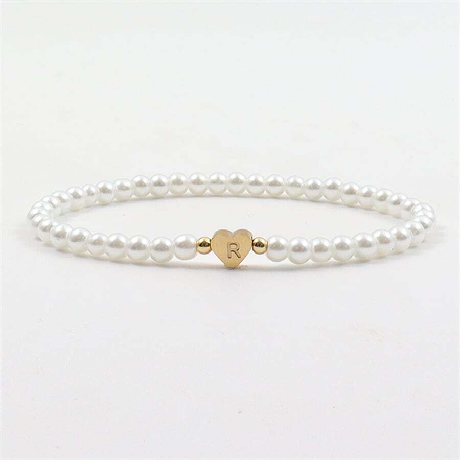 Close-up of the Luna Women's Pearl Bracelet featuring a delicate strand of pearls and a heart charm, worn on a wrist for an elegant and stylish look.