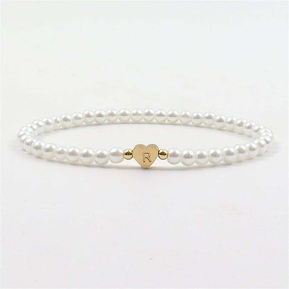 Close-up of the Luna Women's Pearl Bracelet featuring a delicate strand of pearls and a heart charm, worn on a wrist for an elegant and stylish look.
