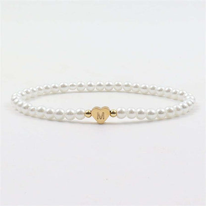 Close-up of the Luna Women's Pearl Bracelet featuring a delicate strand of pearls and a heart charm, worn on a wrist for an elegant and stylish look.