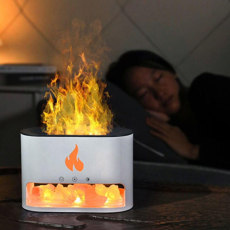 Image showing an aroma diffuser with a sleek design, featuring a button control and a compartment for essential oils, creating a relaxing atmosphere with a flame-like display effect.